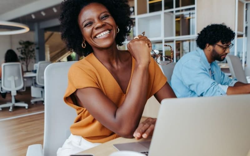 A diverse hiring team collaborating around a laptop
