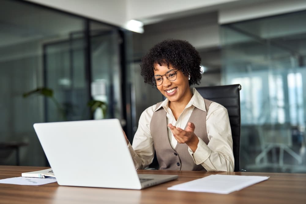 A hiring manager reviewing candidates on her laptop in a modern office